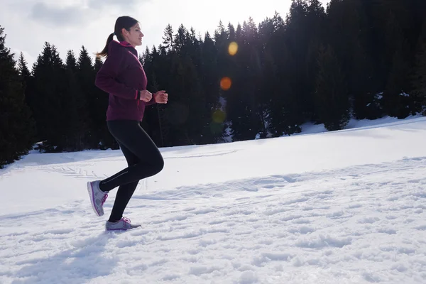 Yougn woman jogging outdoor on snow in forest