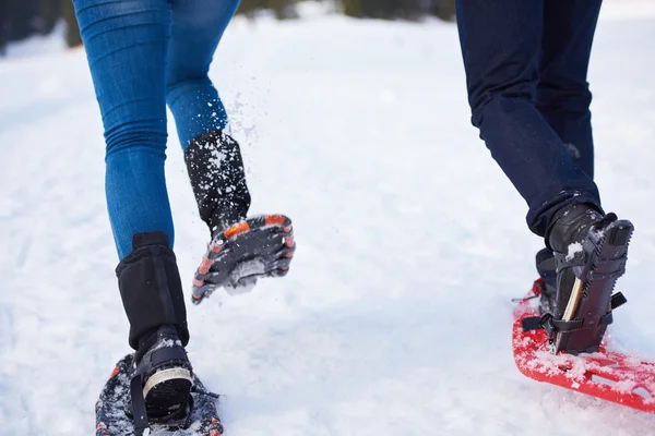 Couple having fun and walking in snow shoes