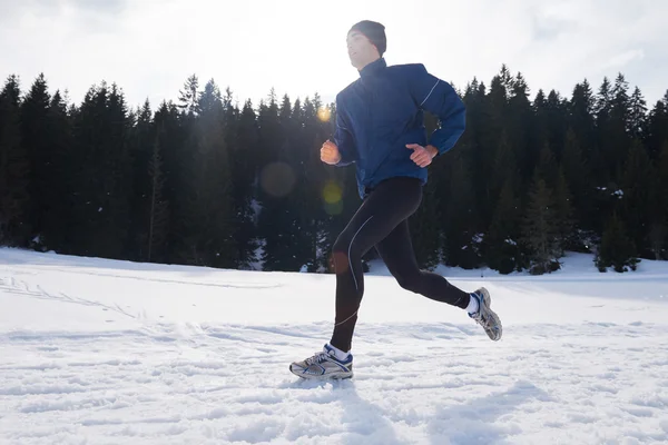 Man jogging on snow in forest