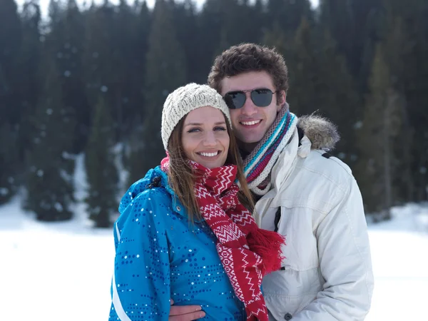 Couple having fun on fresh snow on winter vacation