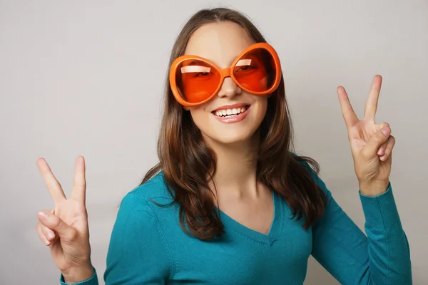 Playful young woman with big party glasses.