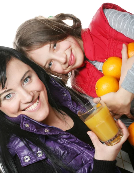 Child with mother holding oranges and juice