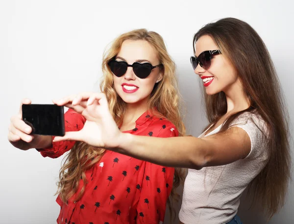 Two teenage girls friends in hipster outfit make selfie