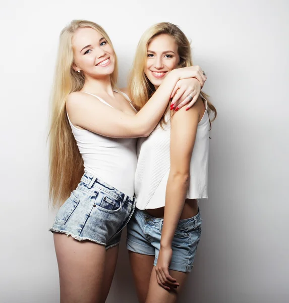 Two young girl friends standing together and having fun