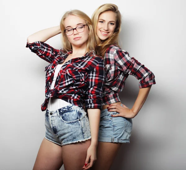 Two young girl friends standing together and having fun.