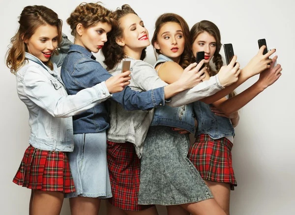 Group of young women looking at their smartphones