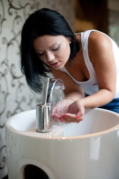 Woman washing her hands in the sink
