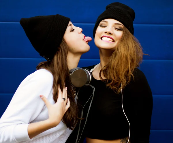 Two young hipster girl friends together having fun.