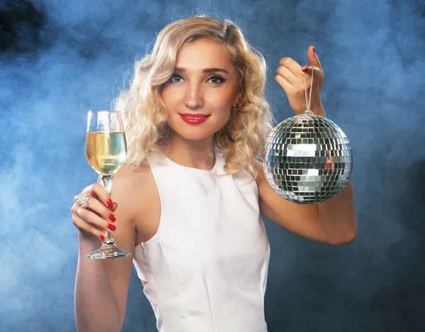 Beautiful woman in evening dress with wine and disco ball
