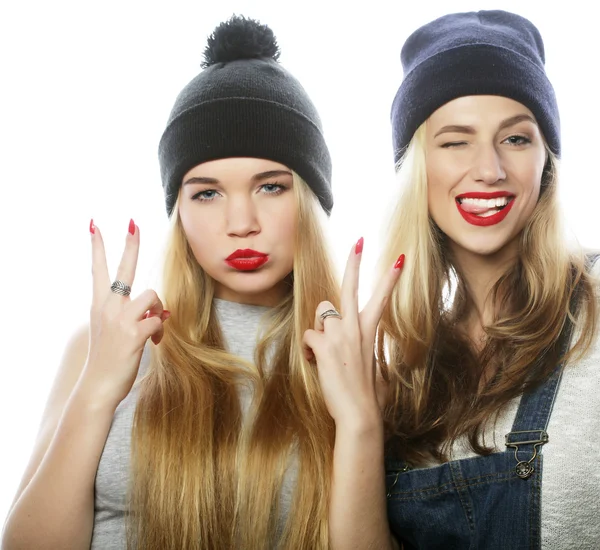 Two young girl friends standing together and having fun.