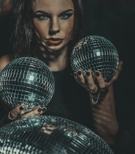 Beautiful young sensual woman holding disco ball