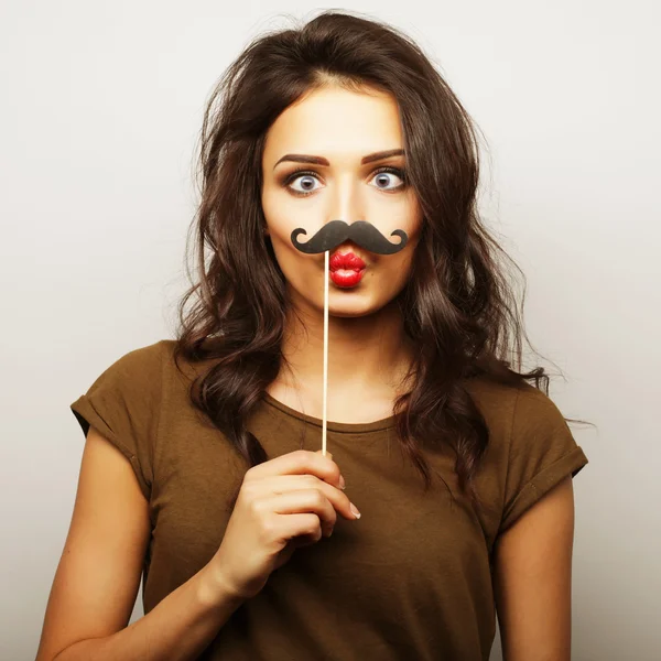 Young woman wearing fake mustaches.