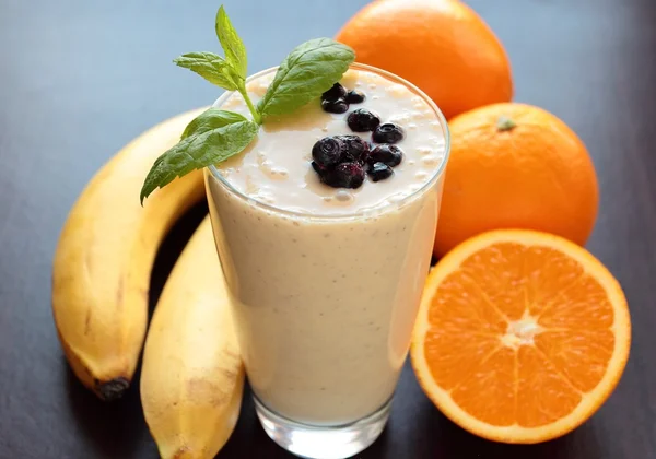 Banana and orange fruits smoothie in a glass