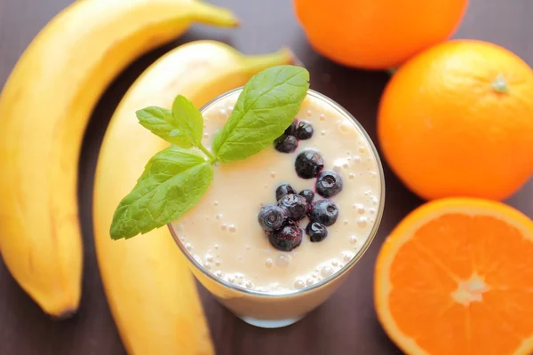 Smoothie with banana, orange and blueberries fruits