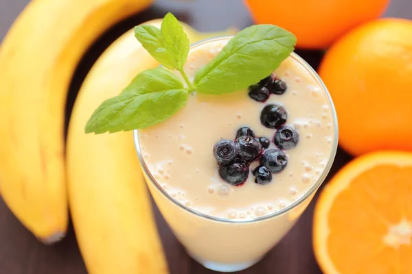 Banana and orange fruits smoothie in a glass
