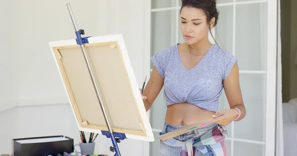 Young female artist painting outdoors