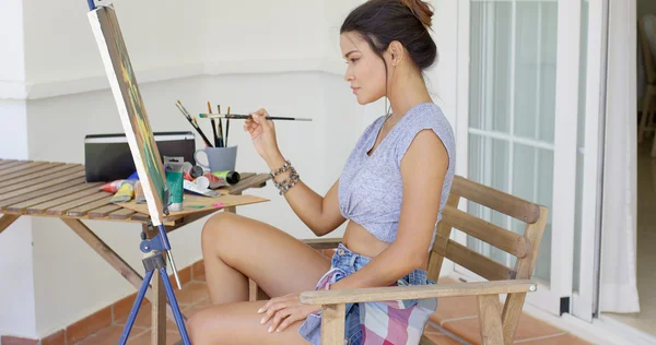 Woman sitting painting on patio