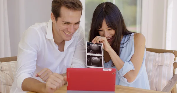 Couple showing off ultrasound pictures