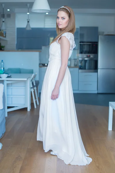 Woman Wearing Wedding Dress Standing in Kitchen