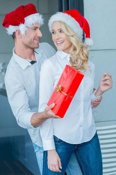 Playful man giving his wife a Christmas gift