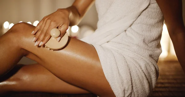 Woman scrubbing leg in spa