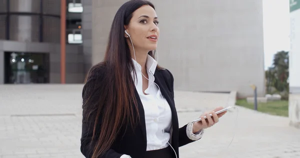 Businesswoman taking call using earplugs