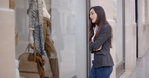 Woman looking at shop mannequin