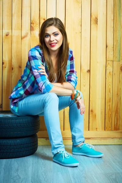 Woman sitting on auto tires