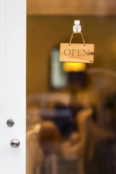 Open sign hanging on door of a store.