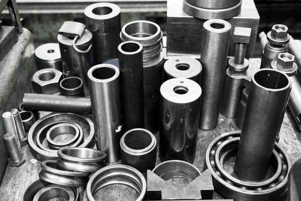 Steel cylinders, pistons and tools in workshop.