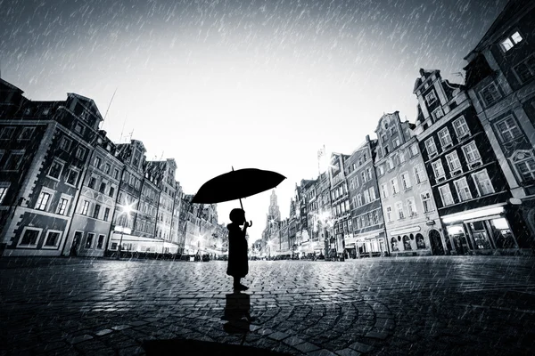 Child with umbrella standing alone