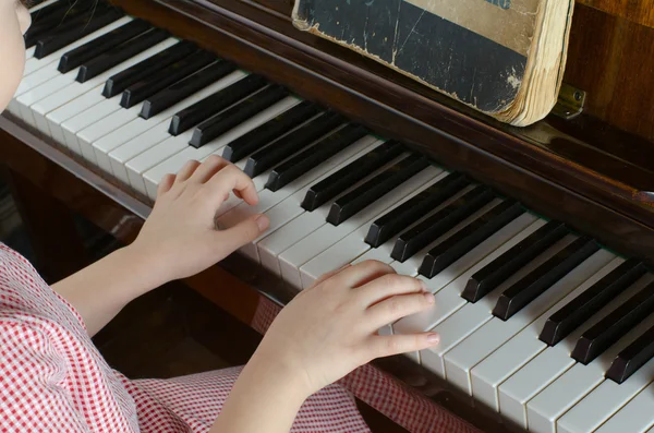 The young girl learns to play a piano