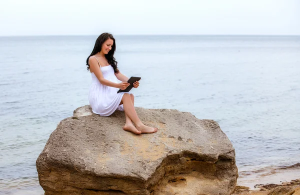 Woman using tablet pc on beach