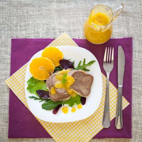 Boiled beef tongue with orange sauce