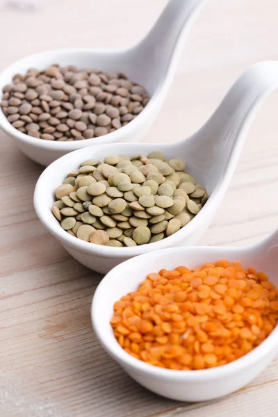 Three kinds of lentil in bowls - red lentil, green lentil and br