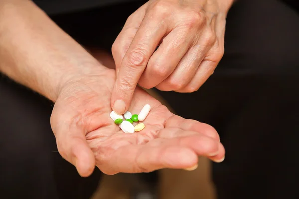 Old man's hands with pills