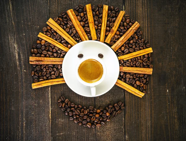 Smiling face made from cup of fresh coffee and beans