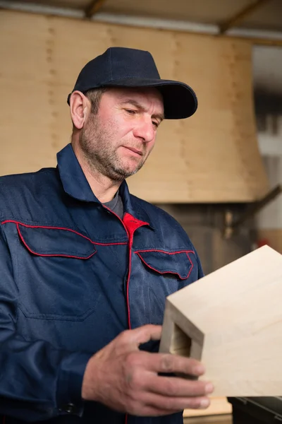 Inspector carpenter inspecting wood furniture part