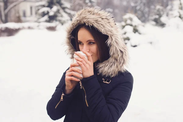 女人从杯子里喝她热的饮料。冬季 - 图库图片#