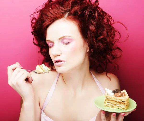 Portrait of pretty girl eating cake, close up