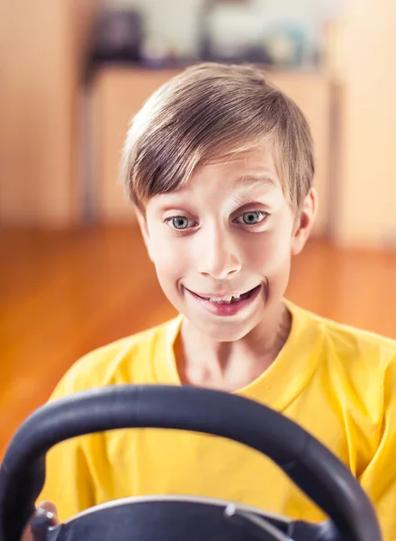 Funny cute little child playing computer game driving looking excited