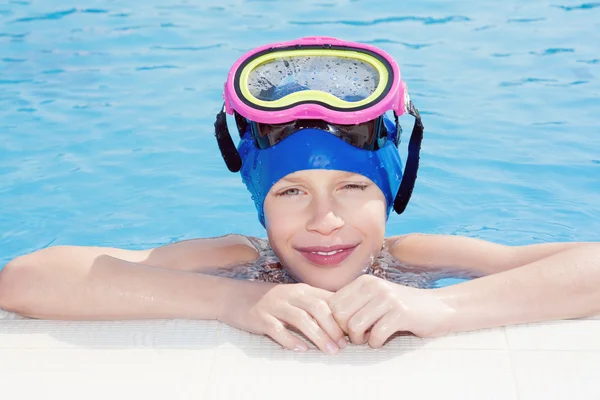 Beautiful happy child wearing swimmer mask in swimming pool smiling (summer vacation concept)