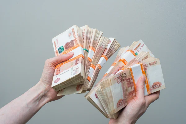 Hand holding many of the Russian banknotes