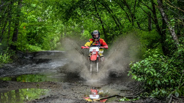 Enduro moto in the mud with a big splash