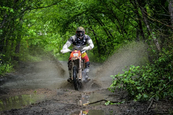 Enduro moto in the mud with a big splash