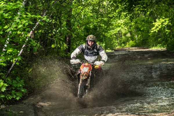 Enduro moto in the mud with a big splash