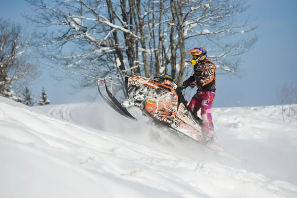 Athlete on a snowmobile moving  in the mountains