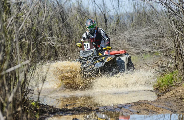 ATV rides through the mud with a big splash