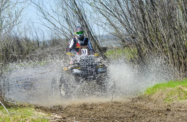 ATV rides through the mud with a big splash