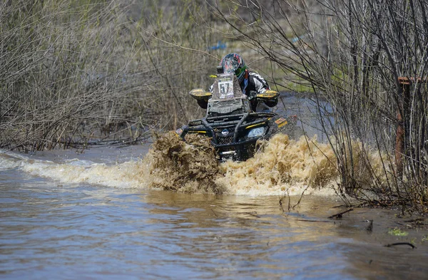 ATV rides through the mud with a big splash